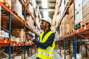 A warehouse manager scanning packages with a bar code reader as a tool to manage operational cost